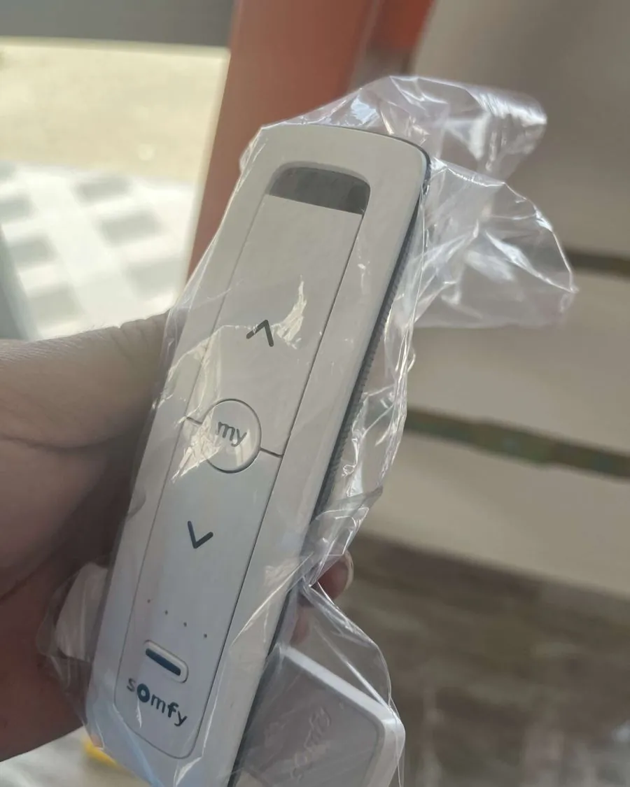 Somfy remote control for motorized curtains held by an installer