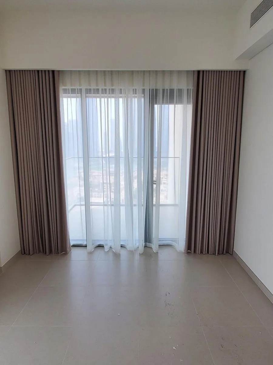 Grey wave curtains with even S-folds in an elegant UAE bedroom