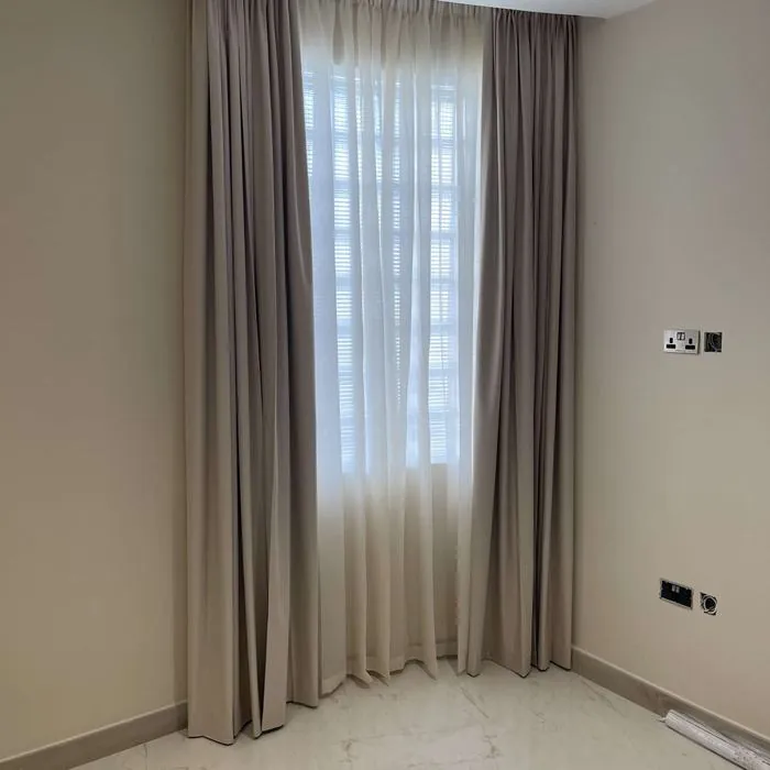Beige made-to-measure curtains in a corner living room