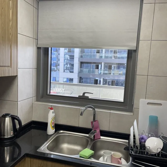 Cream roller blind installed in a kitchen