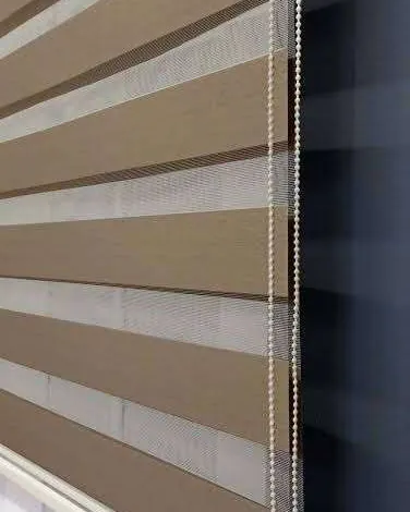 Close-up of beige zebra blind fabric bands